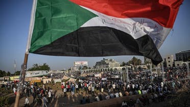 Sudanese protesters gather as they wave national flags during a protest outside the army headquarters in the capital Khartoum on April 21, 2019. (AFP)