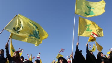 Supporters of the Lebanese Shiite movement Hezbollah fly the group's flag during a speech by the leader to mark the 11th anniversary of the end of the 2006 war with Israel, in the village of Khiam in southern Lebanon on August 13, 2017. 