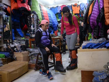 Furdiki Sherpa (L) and Nima Doma Sherpa (R), the Nepali widows of mountaineers, prepare for their Everest expedition at a shop in Kathmandu. (AFP)