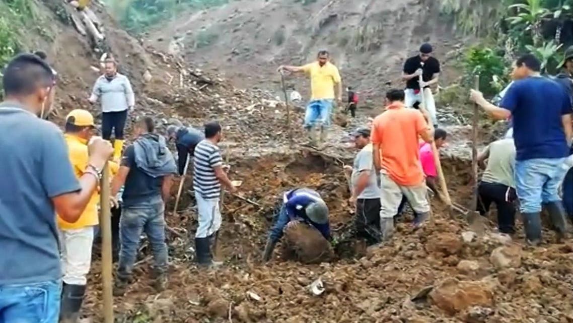 Grab taken from an AFP video showing people searching for others who might be trapped under rubble after a mudslide buried eight houses killing at least 14 people and injuring five in the municipality of Rosas, department of Valle del Cauca in southwestern Colombia, on April 21, 2019. The National Risk Management agency attributed the mudslide to the heavy rains that have battered the country for several weeks. Camilo FAJARDO / AFP