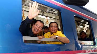 Cambodia’s PM Hun Sen waves beside Thailand’s PM Prayut Chan-O-Cha as they ride a train during a ceremony to connect the railway line between Cambodia and Thailand on April 22, 2019. (AFP)