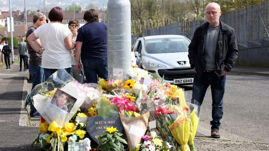 People gather around the floral tributes placed at the scene in the Creggan area of Derry (Londonderry) in Northern Ireland on April 20, 2019, where journalist Lyra McKee was fatally shot amid rioting on April 18. (AFP)