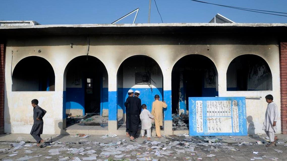 Pakistani children look at a damaged health centre local torched by a mob following rumours of reactions by polio vaccination. afp
