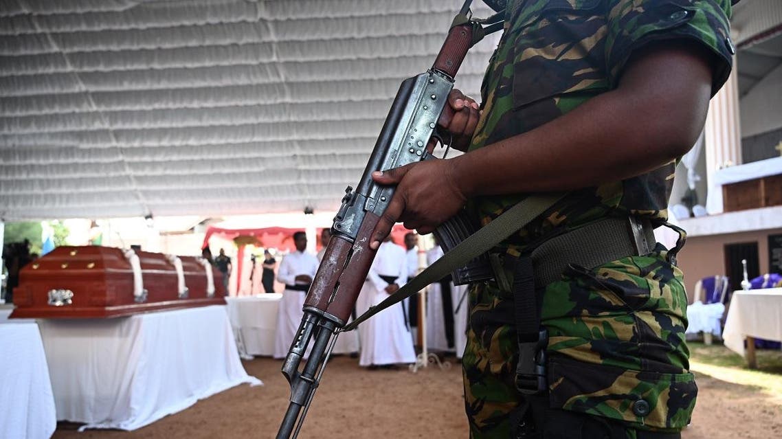 A soldier stands guard near a coffin of a bomb blast victim during a funeral service at St Sebastian’s Church in Negombo on April 23, 2019. (AFP)