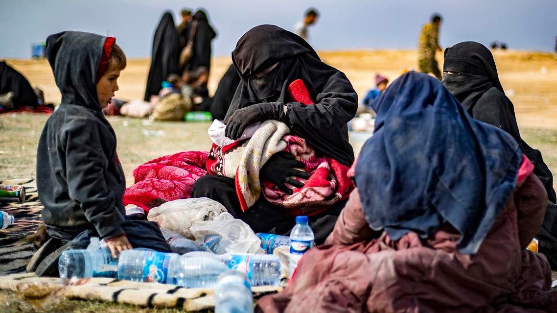 Dorothee Maquere, wife of French jihadist Jean-Michel Clain, sits with four of her five children at a screening area in the eastern Syrian province of Deir Ezzor. (AFP)