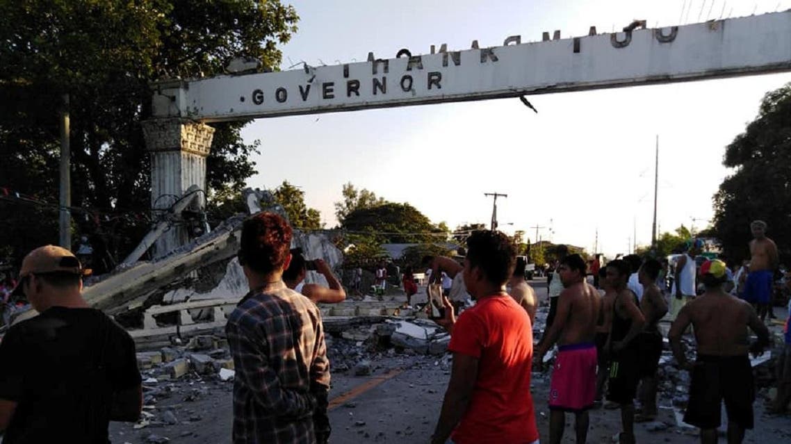 People gather near debris which collapsed and blocked a road after a quake hit Pampanga province, in the Philippines on April 22, 2019, in this photo obtained from social media. (Reuters)