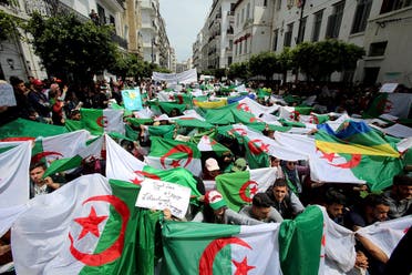 Demonstrators hold flags and banners during anti-government protests in Algiers. (Reuters)