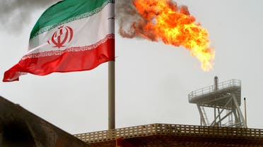 FILE PHOTO: A gas flare on an oil production platform in the Soroush oil fields is seen alongside an Iranian flag in the Persian Gulf, Iran, July 25, 2005. REUTERS/Raheb Homavandi/File Photo/File Photo