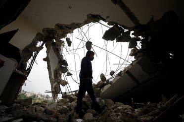 A man walks inside the house of Palestinian assailant Saleh Al-Barghouti after it was partially demolished by Israeli forces in the village of Kobar near Ramallah, in the Israeli-occupied West Bank, on April 17, 2019. (Reuters)