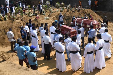 Relatives carry coffins of bomb blast victims for a burial ceremony at a cemetery in Negombo on April 24, 2019. (AFP)