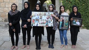 Yazidi woman Ashwaq Haji (1st-L) allegedly used by ISIS as a sex slave, poses for a photograph in tribute to victims from her village of Kocho near Sinjar. (File photo: AFP)