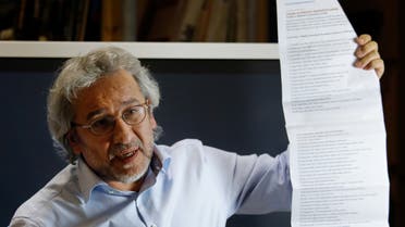 Can Dundar, Turkish journalist and former chief editor of the Turkish daily newspaper Cumhuriyet, holds up a list of journalists in prison in Turkey at a press conference in Berlin on September 28, 2018. Turkish President Recep Tayyip Erdogan confirmed in Berlin that his country is seeking the extradition of Turkish journalist Can Dundar, currently in exile in Germany. Dundar is evading a jail sentence for his Cumhuriyet newspaper's reporting on alleged secret Turkish arms deliveries to Islamist rebels in Syria.
