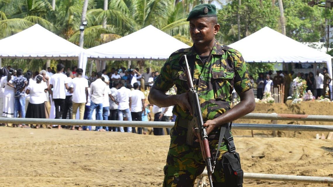 A Sri Lankan soldier stands guard during a burial ceremony for bomb blast victims in a cemetery in Negombo, after a series of bomb attacks targeting churches and luxury hotels in Sri Lanka. (AFP)
