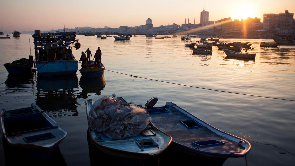 Palestinian fishermen arrive on their boats to the Gaza seaport - AP