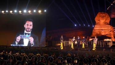 Former Egyptian soccer player Ahmed Hassan is shown on the screen as he participates in the draw for the African Cup of Nations soccer tournament at the historical site of the Giza Pyramids and Sphinx in Cairo. (AP)