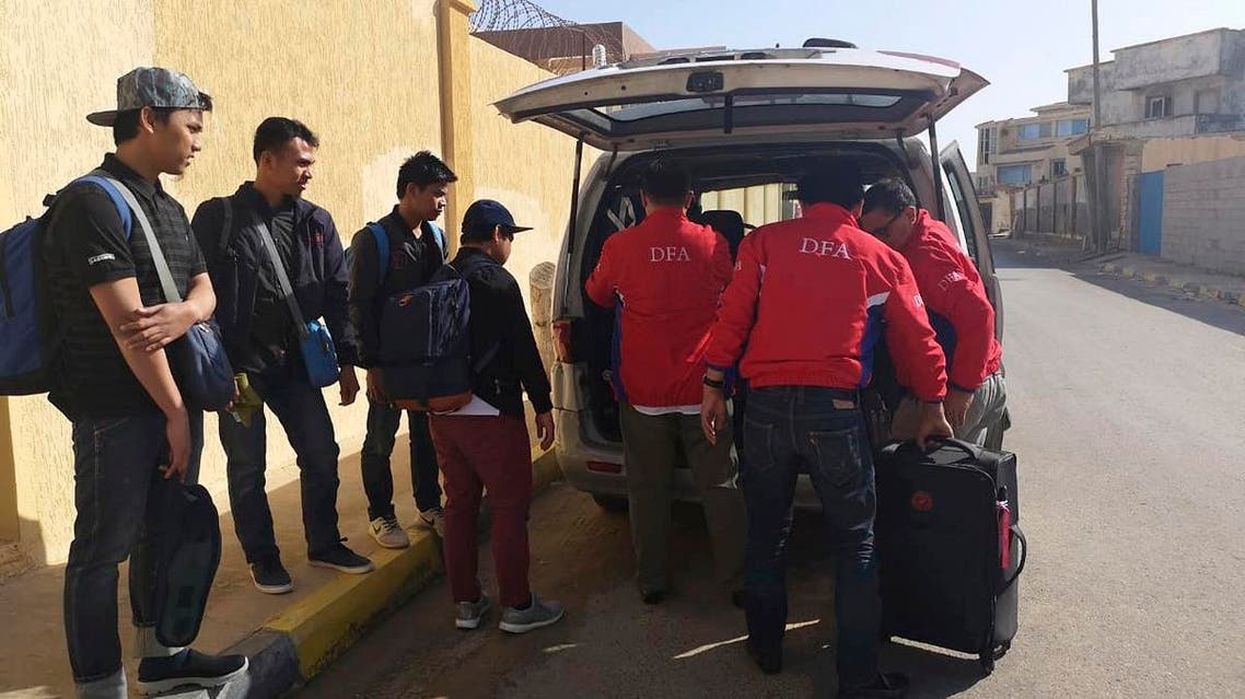 Filipinos are assisted by staff of the department as they are evacuated from Tripoli, Libya. (AP)