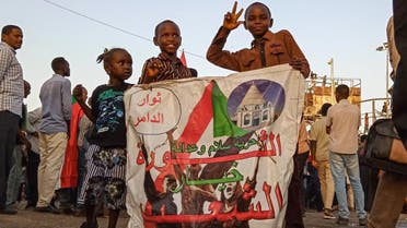 Sudanese children hold a banner reading in Arabic “Revolution is the choice of the people” during a sit-in outside the army headquarters in Khartoum on May 2, 2019. (AFP)