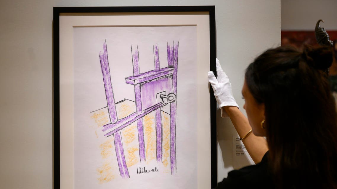 A worker holds a sketch by Nelson Mandela -- "The Cell Door, Robben Island" -- on April 26, 2019 in New York City. AFP