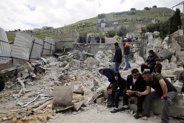 Palestinians sit by a family house destroyed by Israeli authorities in east Jerusalem's neighborhood of Silwan. (File photo: AP)