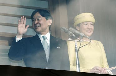 Japan's new Emperor Naruhito, left, waves with Empress Masako, right, to well-wishers from the balcony during his first public appearance with his imperial families at Imperial Palace Saturday (AP)