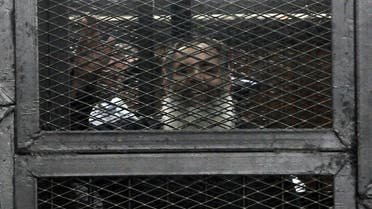 Islamist politician Hazem Salah Abu Ismail waves from inside the defendants cage during his trial in the Egyptian capital Cairo on April 16, 2014. (AFP)