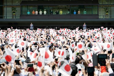 Well-wishers greet Japan's new Emperor Naruhito, center left, and Empress Masako, center right, from the balcony during his first public appearance with his imperial families at Imperial Palace. (AP)
