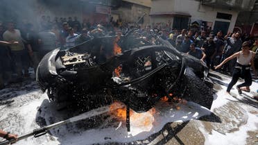 Palestinians try to extinguish a fire in the car of a Hamas commander who was killed in an Israeli air strike, in Gaza City May 5, 2019. (Reuters)