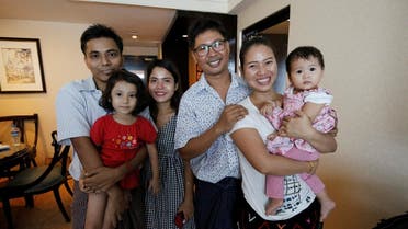 Reuters reporter Wa Lone poses with wife Pan Ei Mon and daughter, along with Reuters reporter Kyaw Soe Oo carrying his daughter next to wife Chit Su Win, after being freed from prison, after receiving a presidential pardon in Yangon. (Reuters)