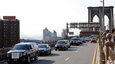 Uber and Lyft drivers, with signs on their vehicles supporting better wages, cross the Brooklyn Bridge in a caravan of about 25 vehicles, on May 8, 2019 in New York. (AP)
