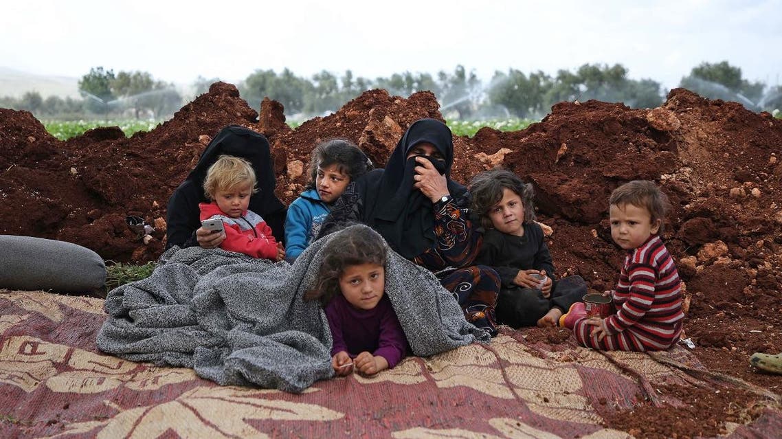 Displaced Syrians gather in a field near a camp for displaced people in the village of Atme, in the northern Idlib province on May 8, 2019. (AFP)