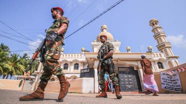Sri Lankan military stand guard outside a mosque after clashes between two sectarian groups in a beachside resort in Poruthota village in Negombo (REUTERS)