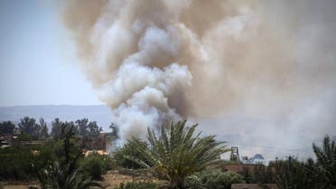 Heavy smoke rises above buildings during clashes about 40 kilometers south of the Tripoli on April 29, 2019. (AFP)