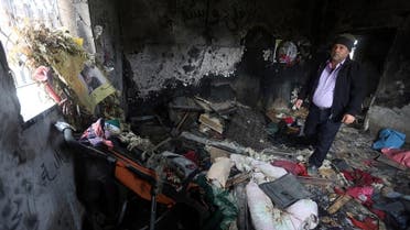 A relative stands on January 3, 2016, inside the burnt-out home of Saad Dawabsha, who was killed alongside his toddler and his wife when their house was firebombed by Jewish extremists on July 31, 2015, in the West Bank village of Duma. (AFP)