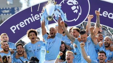 Manchester City's Vincent Kompany lifts the trophy as they celebrate winning the Premier League. (Reuters)