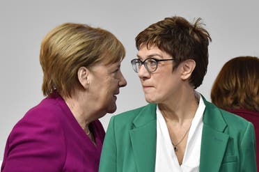 German Chancellor Angela Merkel (L) walks past her successor, newly- elected leader of Germany's conservative Christian Democratic Union (CDU) party Annegret Kramp-Karrenbauer. (AFP)