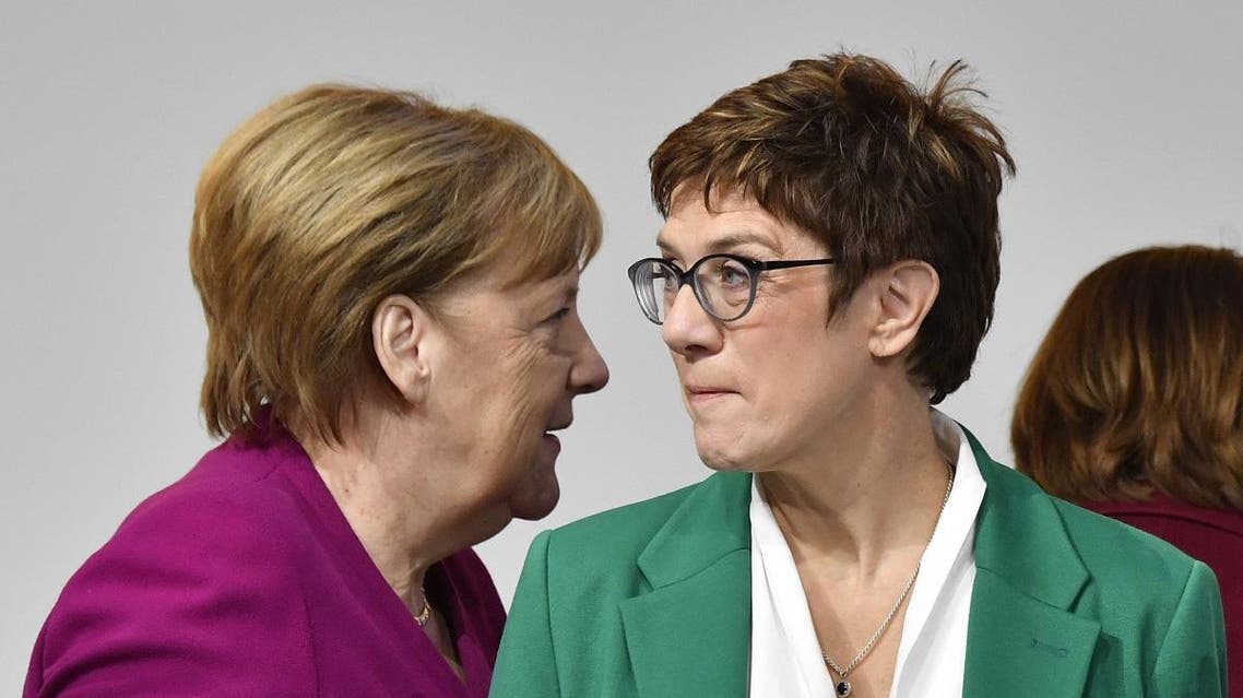 German Chancellor Angela Merkel (L) walks past her successor, newly- elected leader of Germany's conservative Christian Democratic Union (CDU) party Annegret Kramp-Karrenbauer. (AFP)