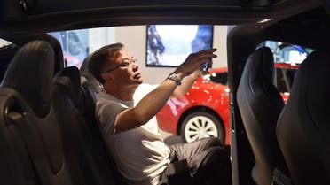 A man takes a photo inside a Tesla Model X in a Tesla showroom in Beijing. (AFP)