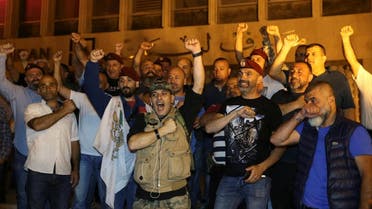 Retired soldiers gesture as they take part in a protest over proposed cuts to the cost of military pensions and benefits in front of the central bank in Beirut. (Reuters)