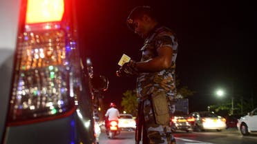 A Sri Lankan security personnel inspects a car on a controlled roadside in Colombo. (AFP)
