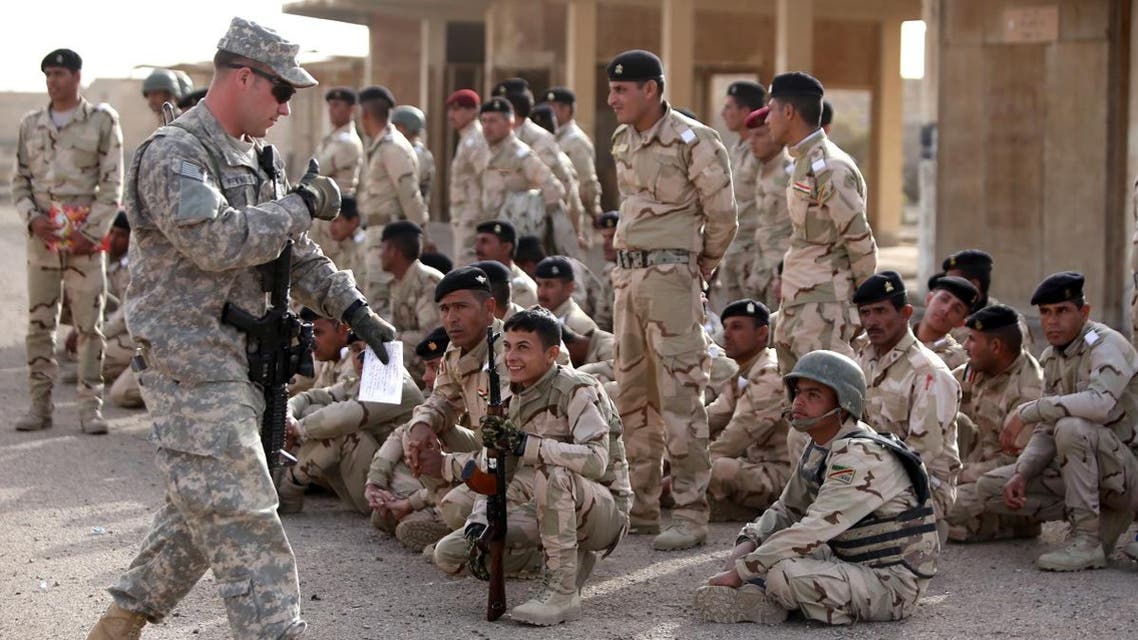 An American military trainer gives a thumbs up to an Iraqi soldier during an exercise on approaching and clearing buildings at the Taji base complex, which hosts Iraqi and US troops and is located north of the capital Baghdad, on January 7, 2015. Taji is one of an eventual five sites from which the US and allied countries aim to train 5,000 Iraqi military personnel every six to eight weeks for combat against the ISIS