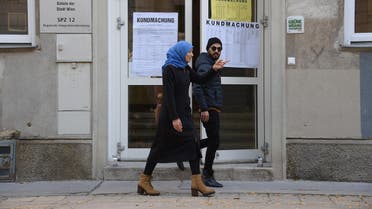 A woman wearing a headscarf and a man leave a polling station during general elections in Vienna on October 15, 2017. (AFP)