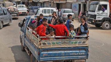 Syrian children, riding on the back of a truck, flee from shelling on Hama and Idlib provinces on May 1, 2019. (AFP)