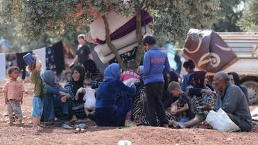 Displaced Syrians sit together in an olive grove in Atmeh town, Idlib province, Syria May 15, 2019. Picture taken May 15, 2019. (Reuters)