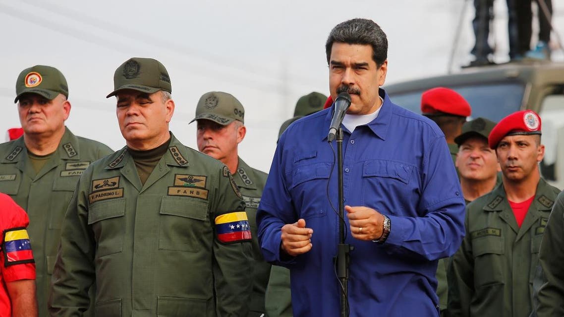 Handout photo released by Miraflores Palace press office showing Venezuela's President Nicolas Maduro (C) and Defense Minister Vladimir Padrino (C-R) raising their arms during the march of loyalty with the Superior Staff of the Venezuela's Bolivarian National Armed Forces (FANB) and all military personnel stationed in the ZODI Aragua state, Venezuela on May 17, 2019. (AFP)