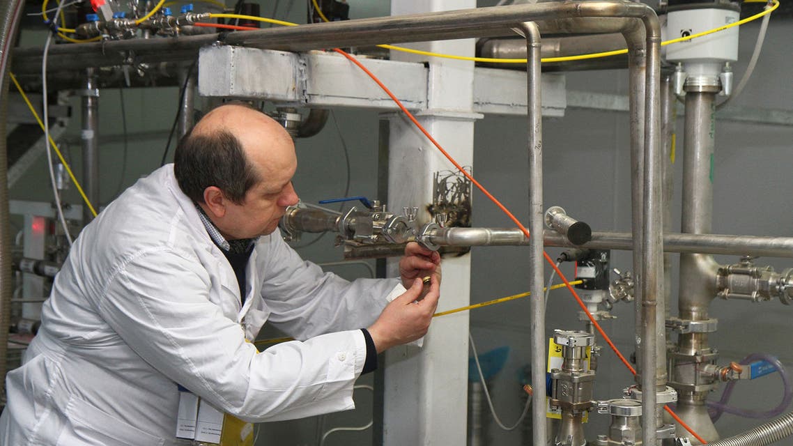Unidentified International Atomic Energy Agency (IAEA) inspectors seal after disconnecting the connections between the twin cascades for 20 percent uranium production at nuclear power plant of Natanz, some 300 kilometres south of Tehran on January, 20, 2014 as Iran halted production of 20 percent enriched uranium, marking the coming into force of an interim deal with world powers on its disputed nuclear programme. AFP PHOTO/IRNA/KAZEM GHANE