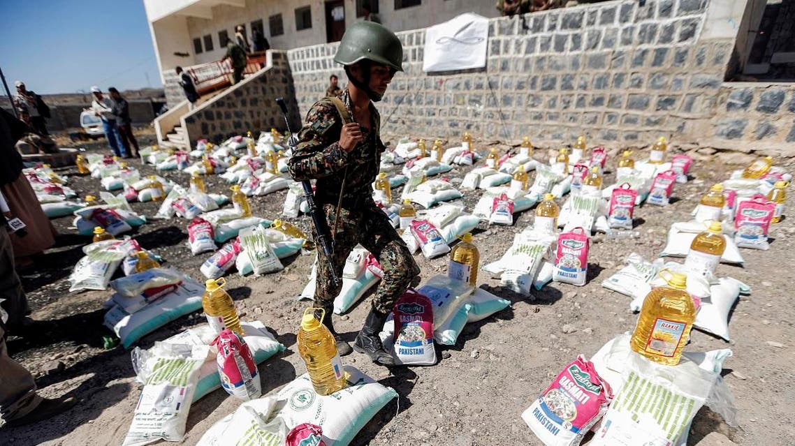 A Yemeni Houthi walks next to humanitarian aid supplies in a camp on the outskirts of the capital Sanaa on March 16, 2017. (AFP)