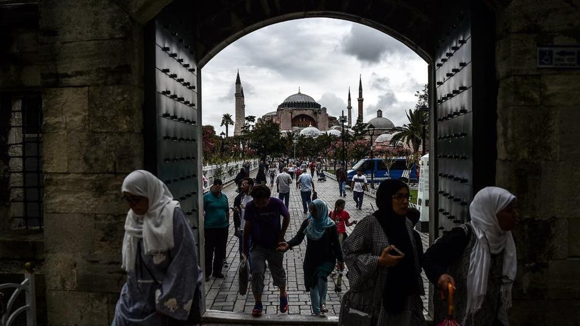 People enter to Sultanahmet (Blue) mosque on August 22, 2017 near the Hagia Sophia (in the background) during a rainy day in Istanbul. afp