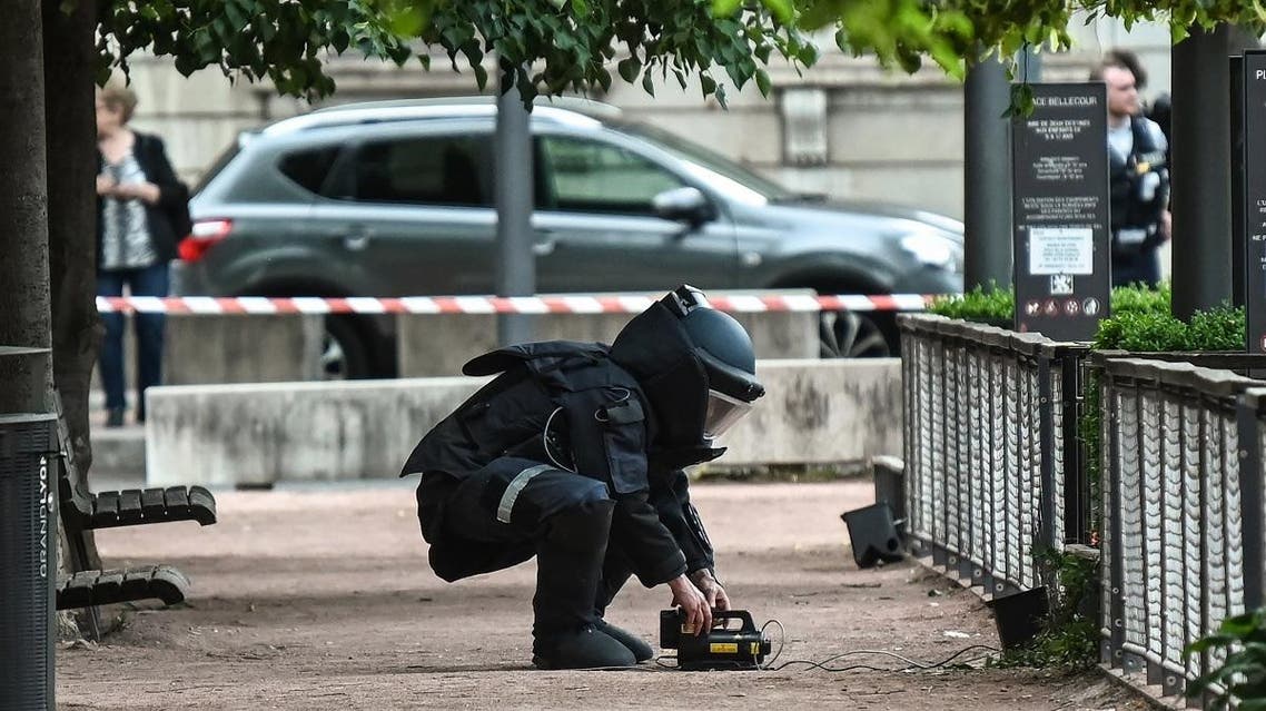 A bomb disposal expert works at the scene of a suspected package bomb blast along a pedestrian street in the heart of Lyon, southeast France, on May 24, 2019.