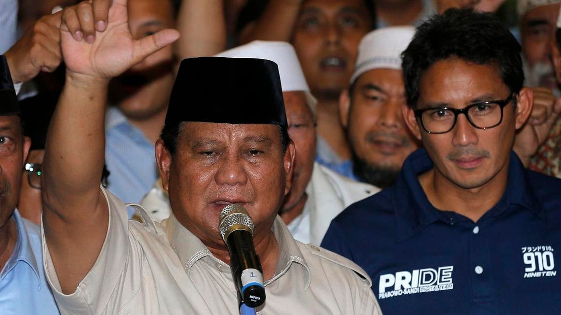 Indonesian presidential candidate Prabowo Subianto, left, raises his hands as his running mate Sandiaga Uno looks on during a speech declaring their victory in April 17 election in Jakarta, Indonesia, Thursday, April 18, 2019. (AP)
