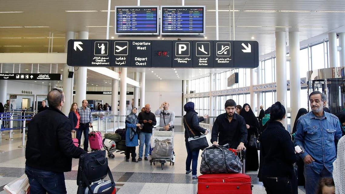 Travelers check the flight schedule screens for delays or cancellations, at the departure terminal of Rafik Hariri international airport in the Lebanese capital, Beirut. (AFP)
